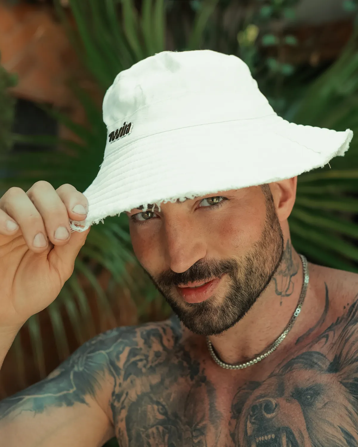 Maximo Garcia con un sombrero blanco de pescador, sonriendo a la cámara